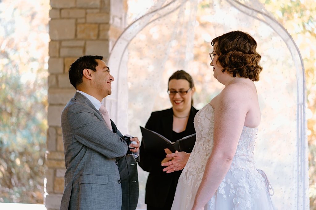 A bride and groom exchange vows at their elopement ceremony at the Grove Redfield Estate.