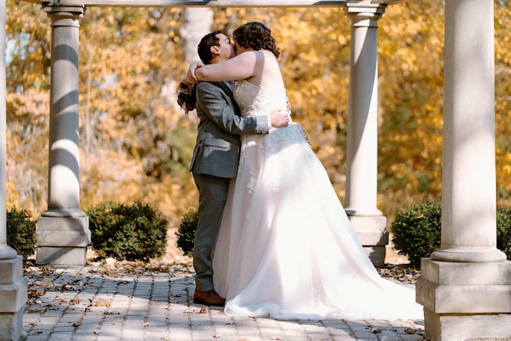 The bride and groom taking their wedding portraits under the gazebo at the Grove Redfield Estate.