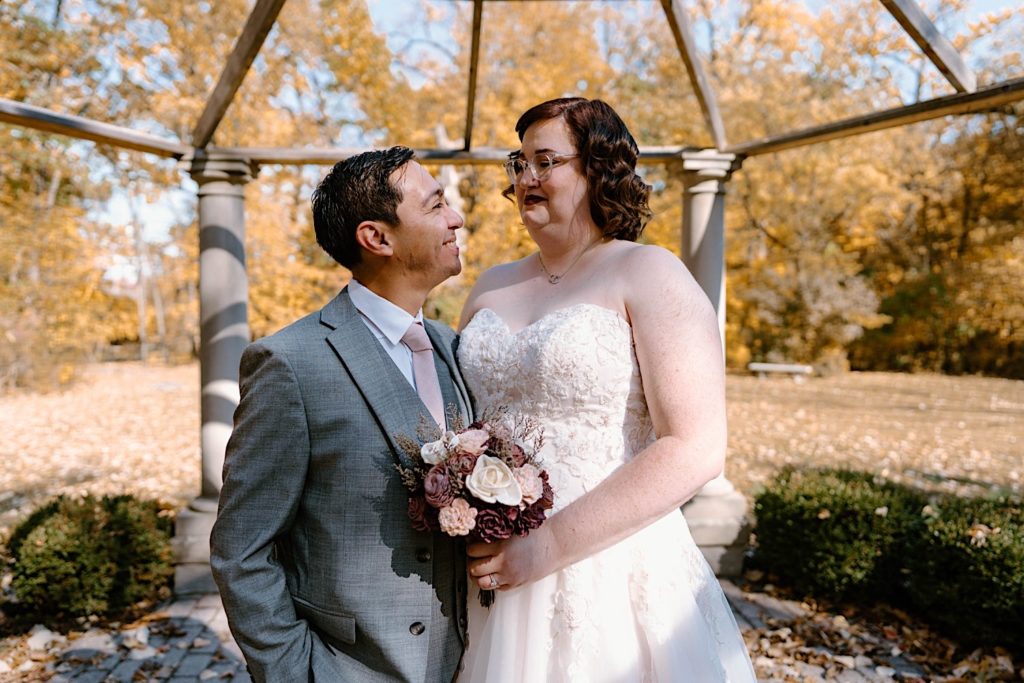 The bride and groom taking their wedding portraits under the gazebo at the Grove Redfield Estate.