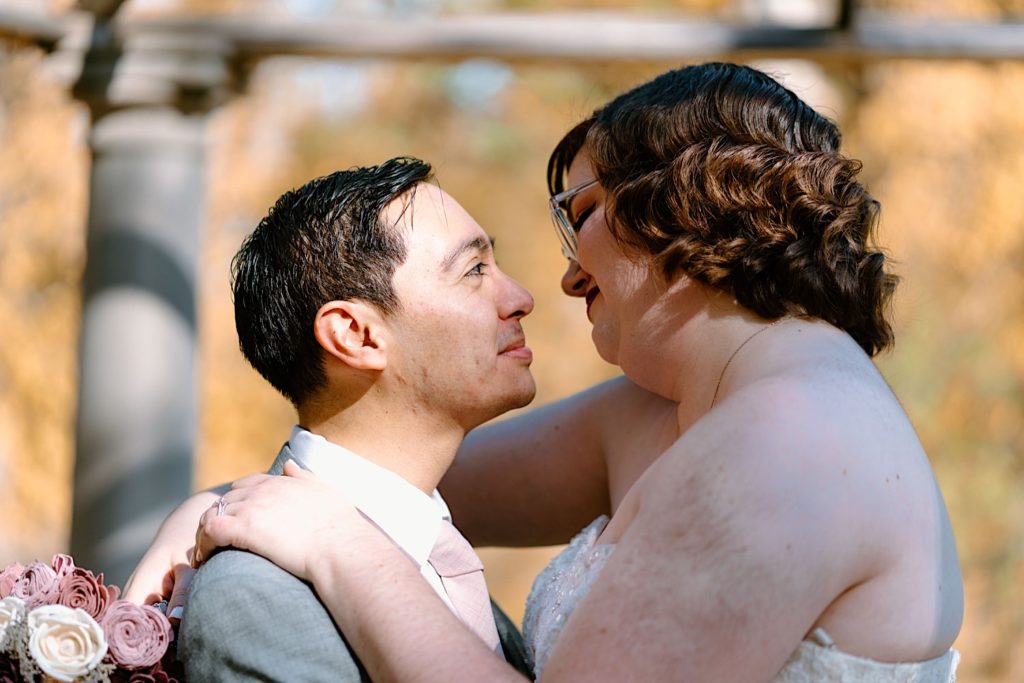 The bride and groom taking their wedding portraits under the gazebo at the Grove Redfield Estate.
