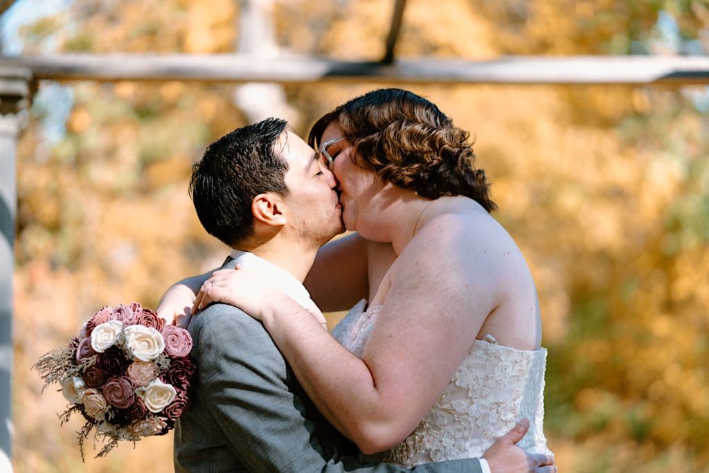 A bride and groom walk through the Grove Redfield Estate in the fall after their elopement ceremony.