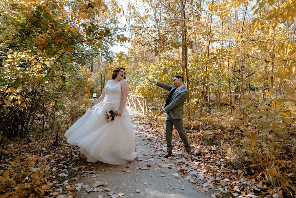 A bride and groom walk through the Grove Redfield Estate in the fall after their elopement ceremony.