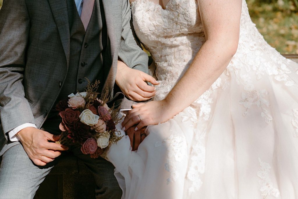 A bride and groom sit together at the Grove Redfield Estate in the fall after their elopement ceremony.