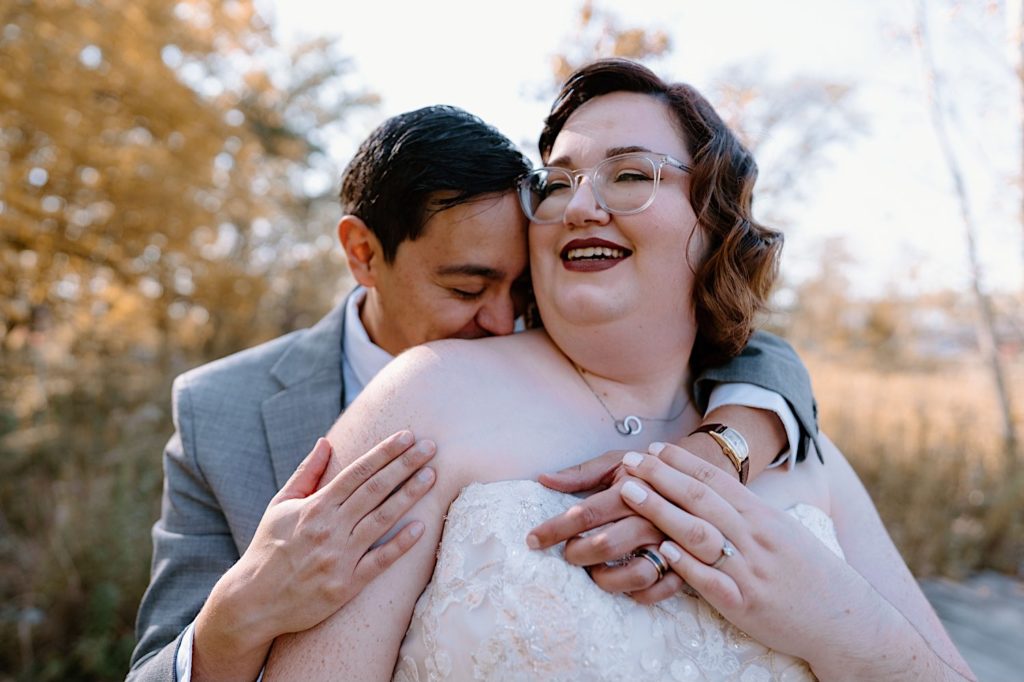 A bride and groom walk through the Grove Redfield Estate in the fall after their elopement ceremony.