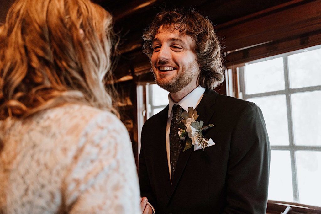 A bride and groom look at one another smiling at each other in their cabin at Starved Rock.