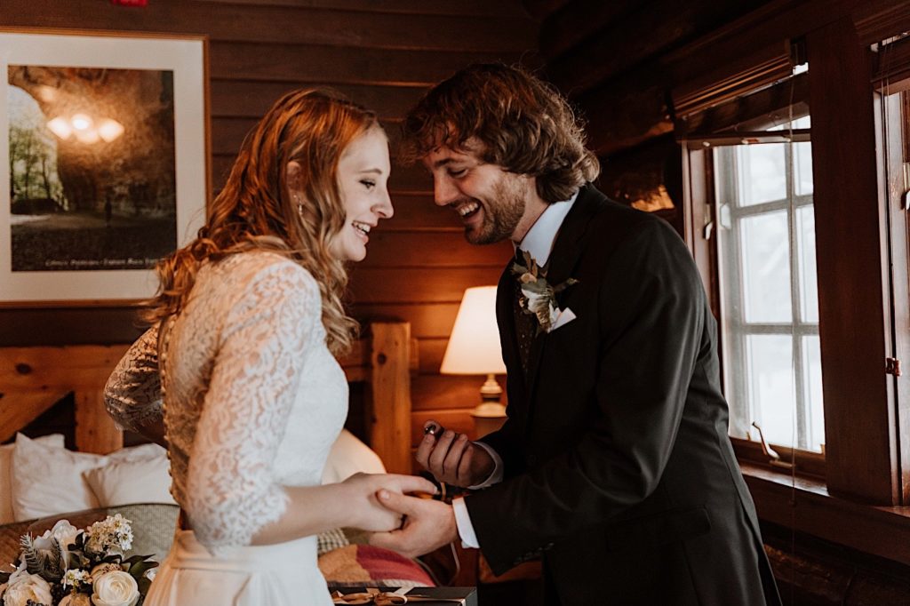 A bride and groom look at one another smiling at each other in their cabin at Starved Rock.