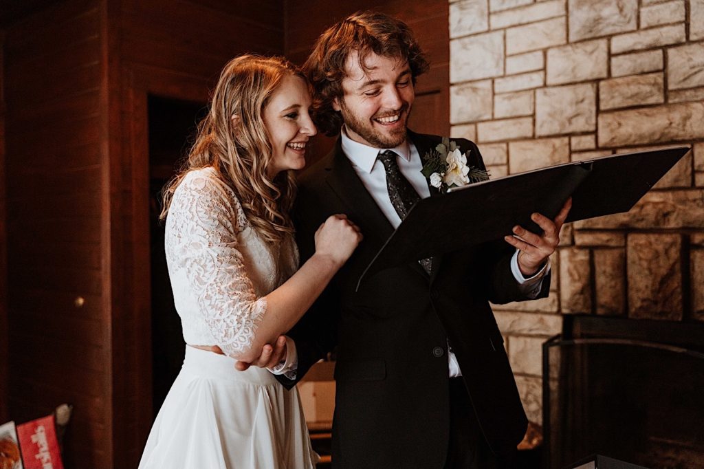 A groom opens a gift from his bride the morning of their elopement at Starved Rock National Park
