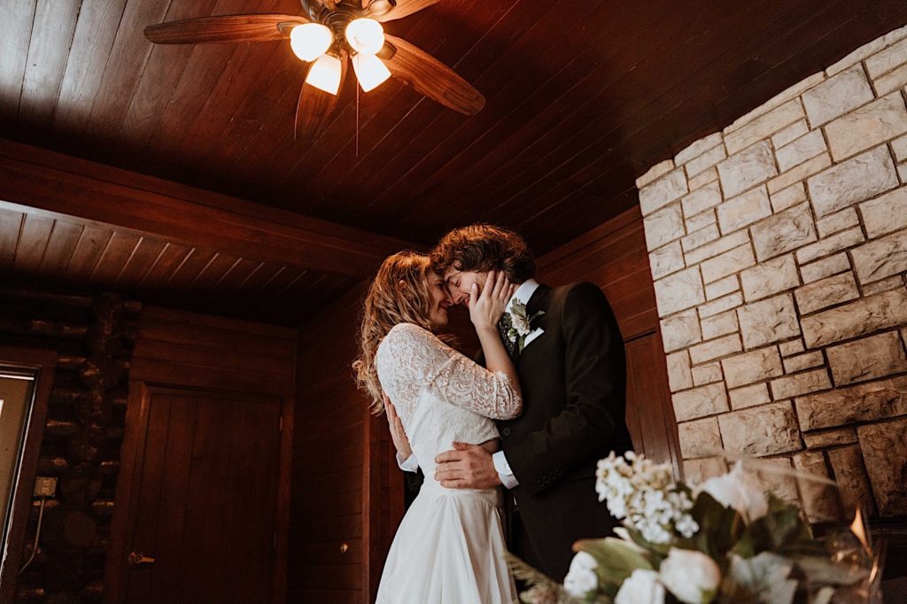A bride and groom kiss one another lovingly after exchanging gifts at their wedding in their cabin at Starved Rock National Park
