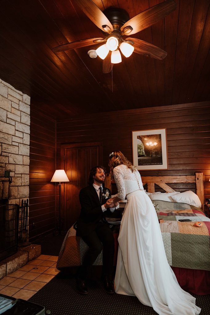 A bride and groom sit reading letters to one another while reading letters from family and friends before they elope at Starved Rock National Park
