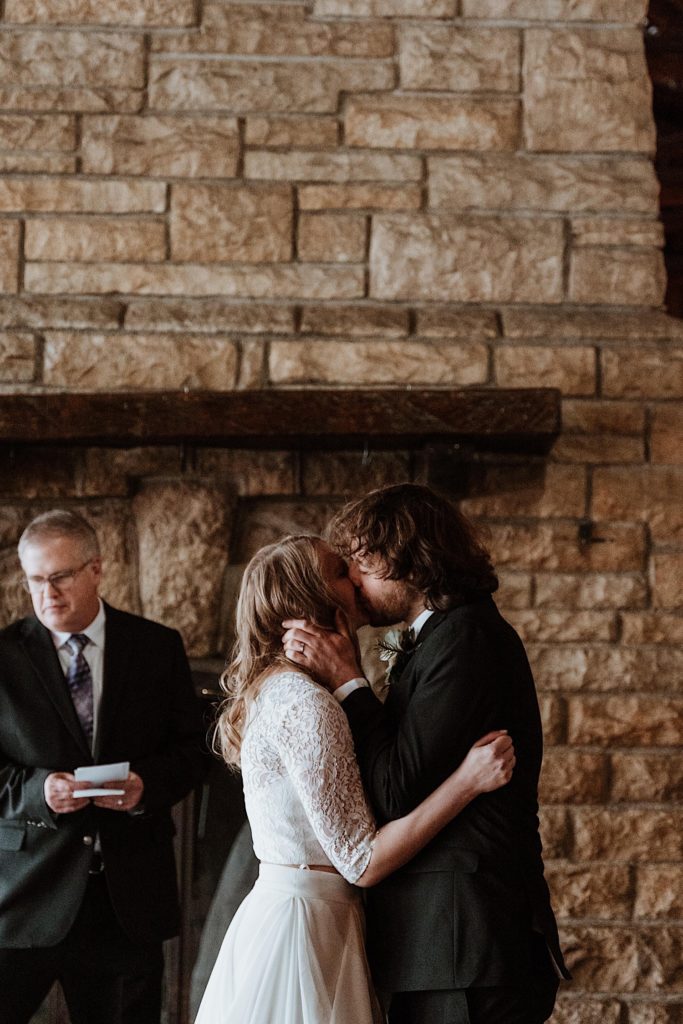 A bride and groom kiss during their wedding ceremony at a cabin in Starved Rock National Park