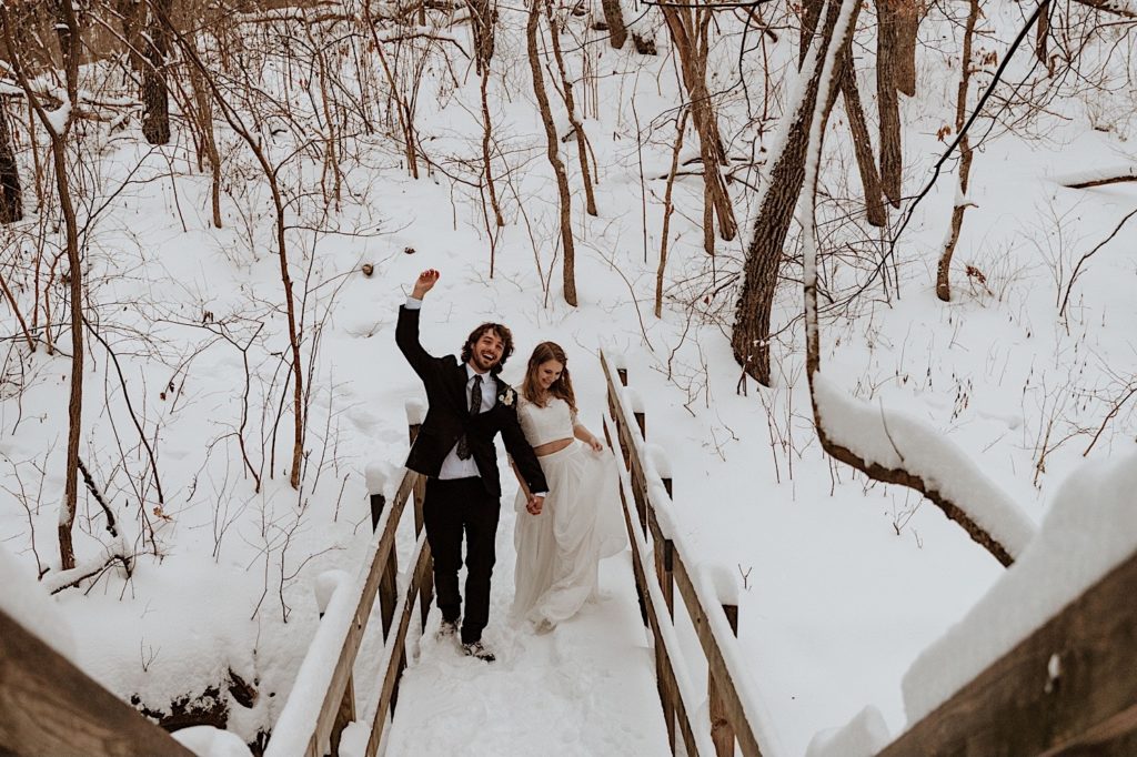 A bride and groom snuggle in close while standing on a bridge in Starved Rock National Park.