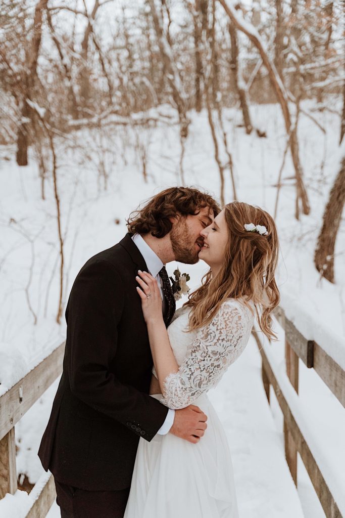 A married kisses one another on a bridge while taking their wedding portraits at Starved Rock National Park