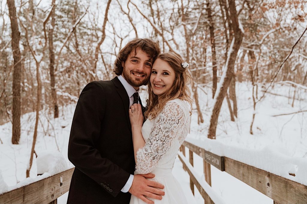 A married holds one another on a bridge while taking their wedding portraits at Starved Rock National Park