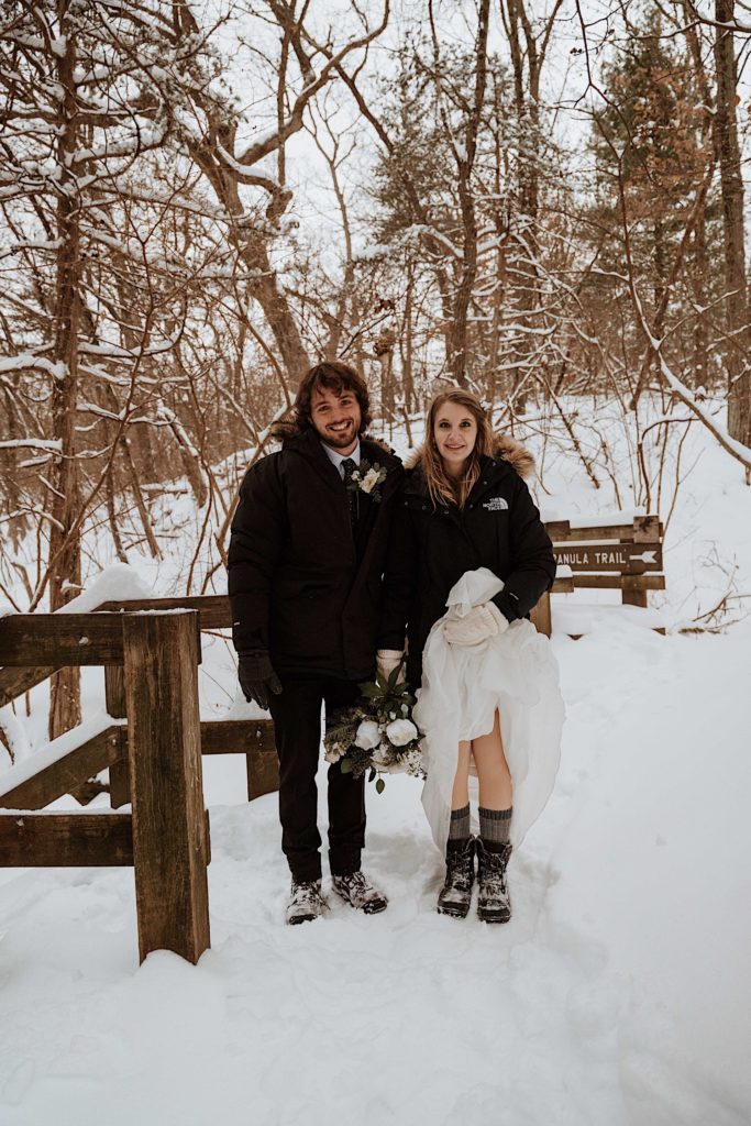 A couple stands next to one another in their winter coats during their winter elopement at Starved Rock National Park.