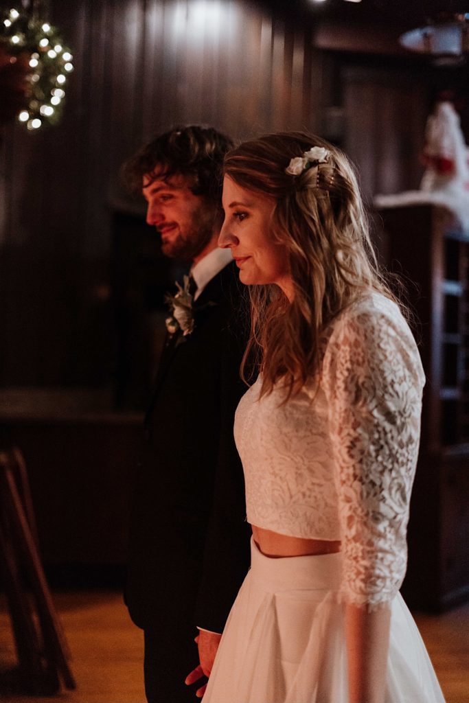 A bride and groom hold hands standing in front of the fireplace after taking their wedding portraits at Starved Rock National Park.