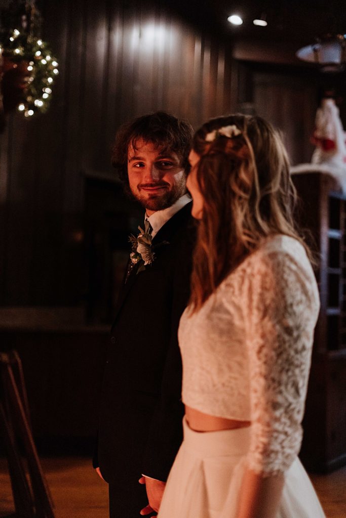 A bride and groom hold hands standing in front of the fireplace after taking their wedding portraits at Starved Rock National Park.