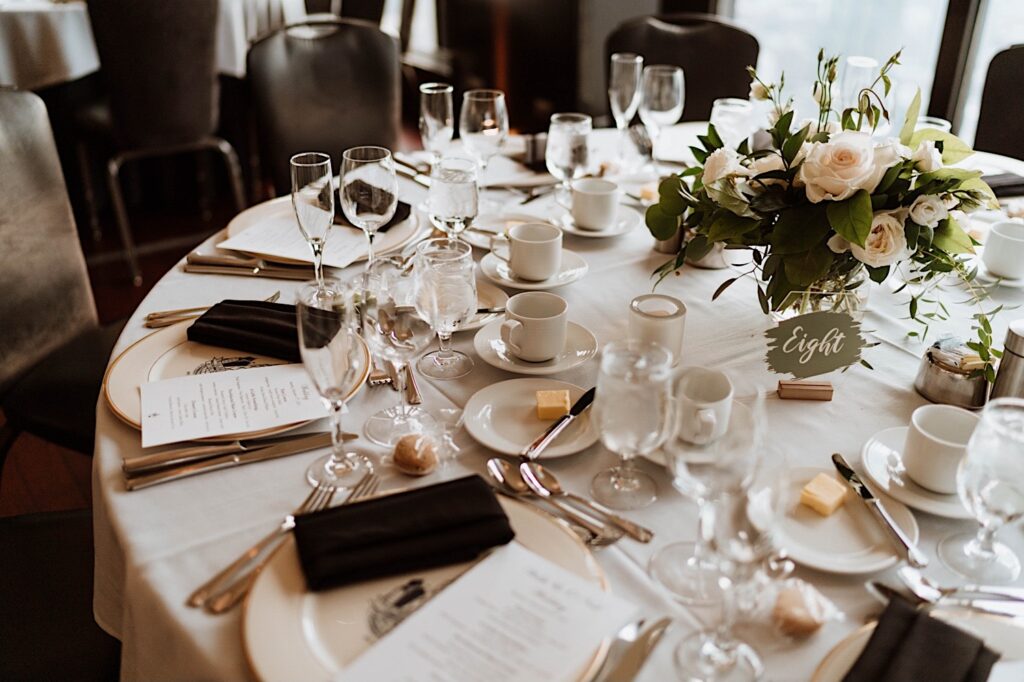 A wedding table scape with olive tones and white roses