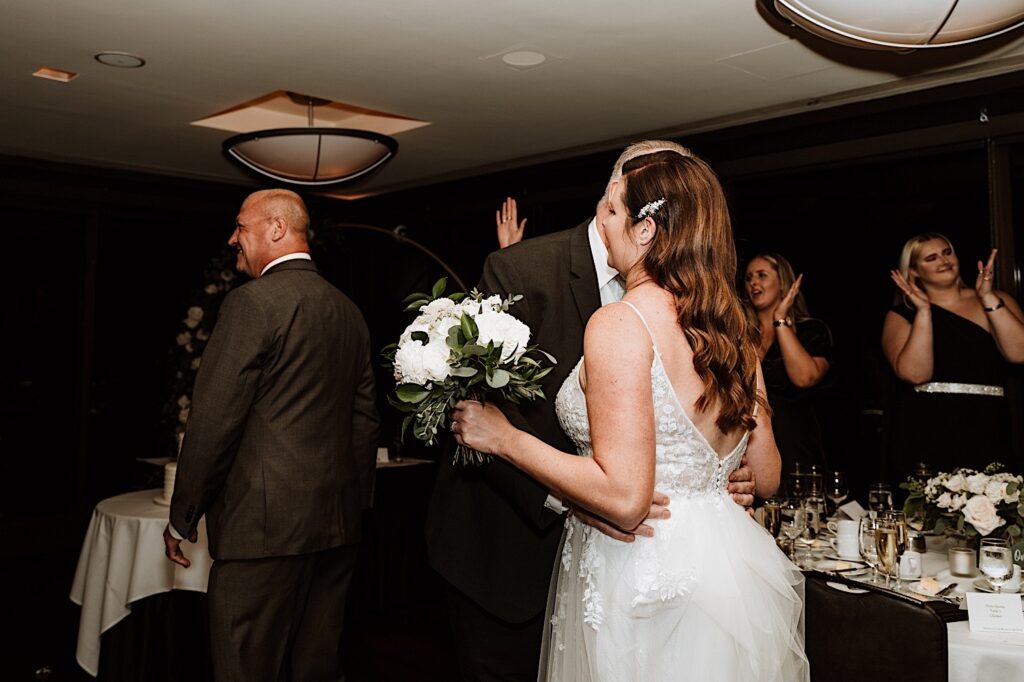 A groom kisses his new wife on the cheek during their reception at their Chicago wedding venue.