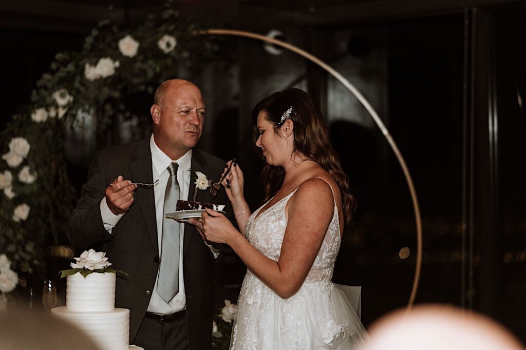A bride and groom feed each other cake during their wedding reception at their Chicago wedding.