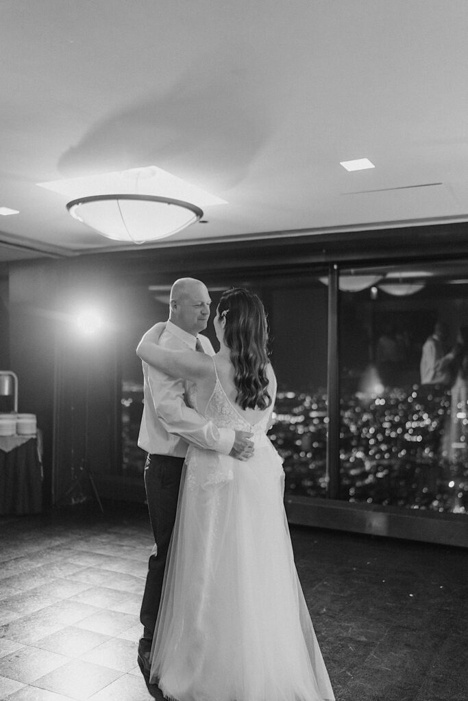 A bride and groom have their first dance at the Signature Room on the 95th floor.