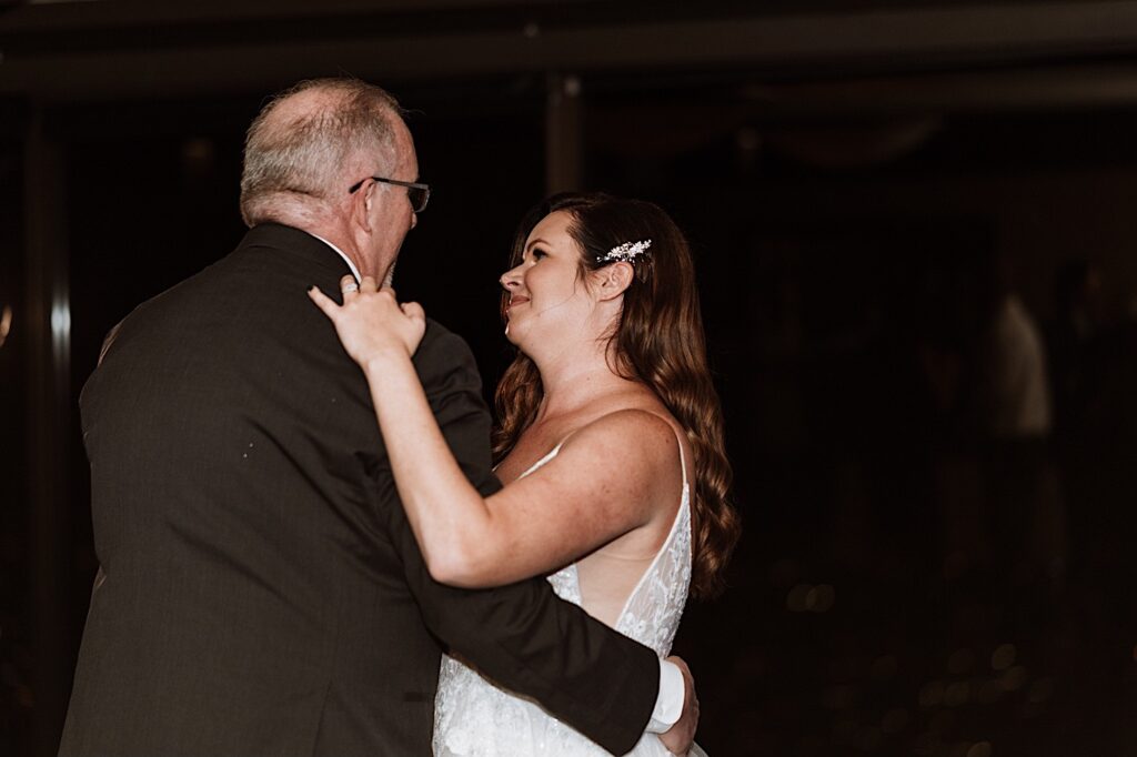 A bride and her father have their first dance at the Signature Room on the 95th floor.