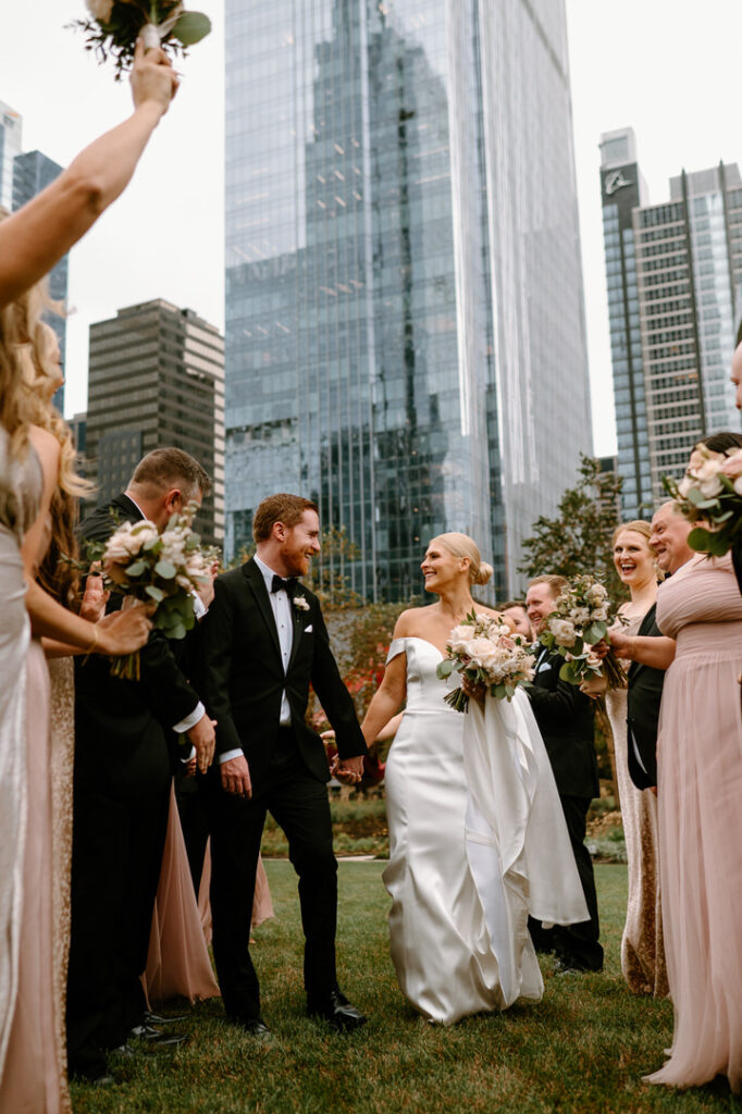 bride and groom walking down the aisle made by their wedding party