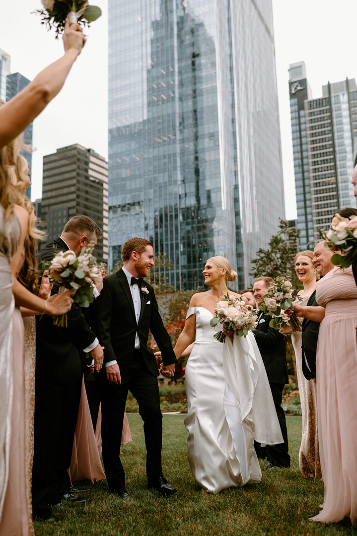 bride and groom walking down the aisle made by their wedding party